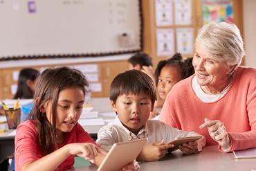 old lady teaching two kids a girl and a boy
