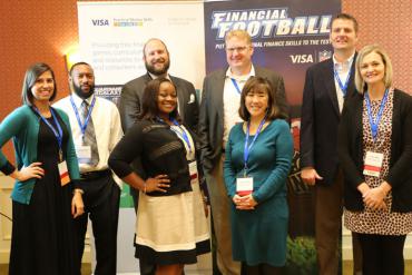 a group of people standing in front of financial football banner