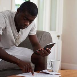 a man sitting on couch holding a calculator