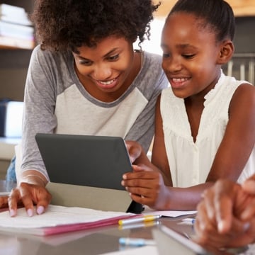 teacher and student holding a tab 